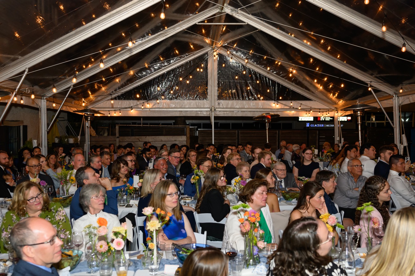 Wide shot of reception crowd watching speeches