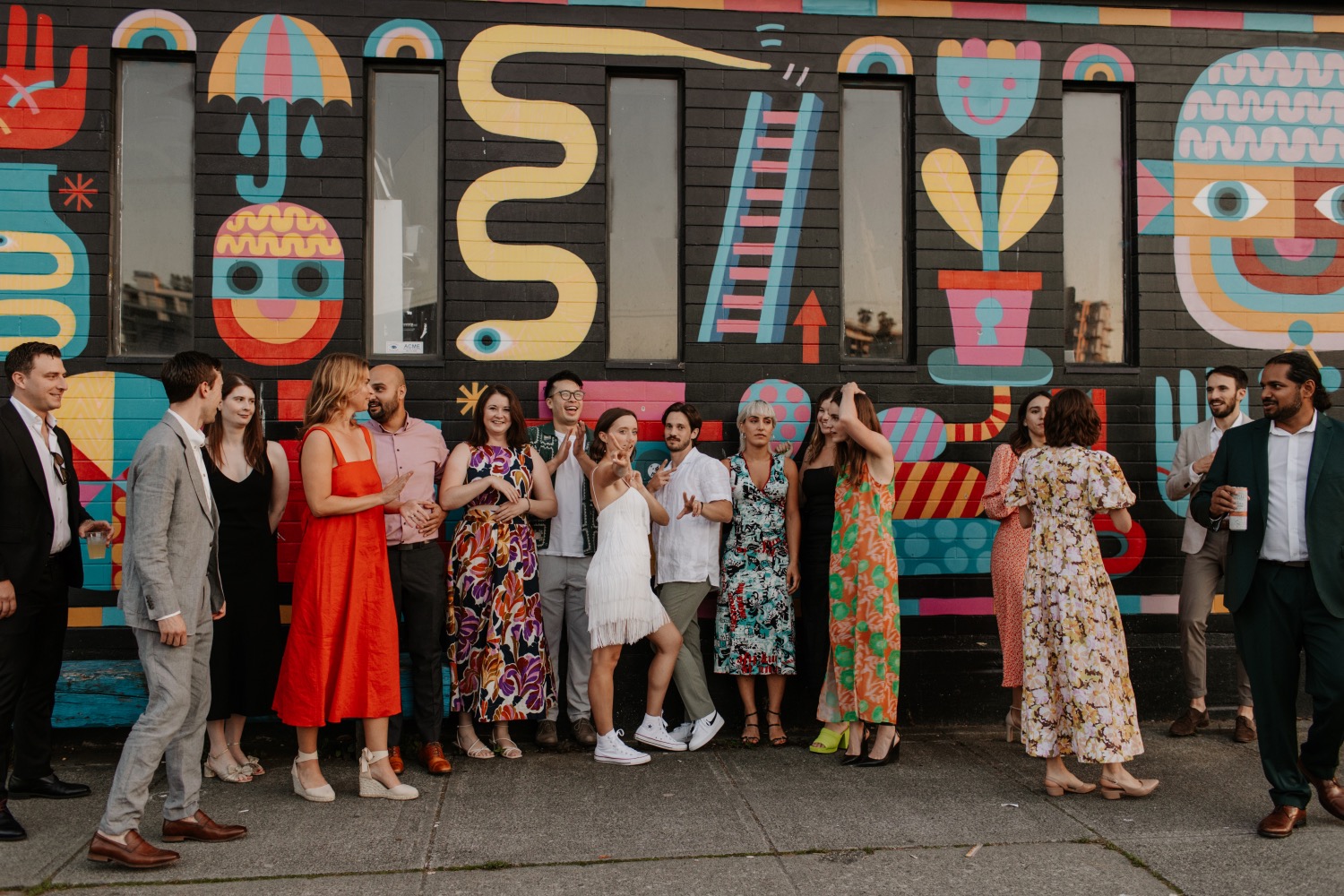 Wedding party group photo against the Beaumont Studios mural wall